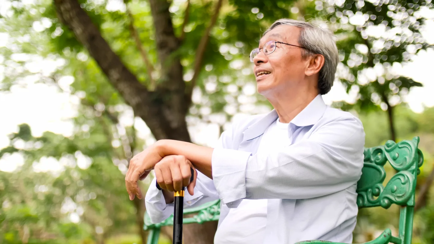 Happy asian man sitting on a bench at the park 2025 02 22 07 59 29 utc